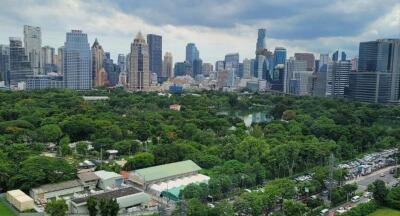 Aerial view of a cityscape with residential and commercial buildings, and a large green park.