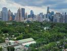 Aerial view of a cityscape with residential and commercial buildings, and a large green park.