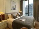 Spacious bedroom with city view, featuring a large bed, bedside tables with lamps, and modern decor