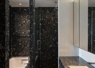 Modern bathroom with black marble finishes and large mirrors