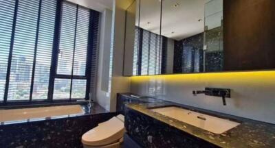 Modern bathroom with black marble surfaces and ample natural light