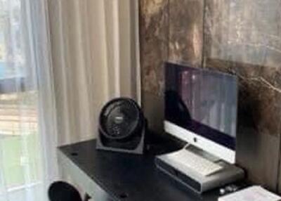 Home office with computer and fan on desk