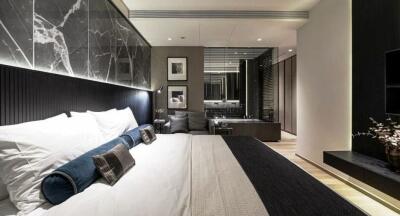 Modern, well-lit bedroom with a large bed, elegant decorations, and a sleek design