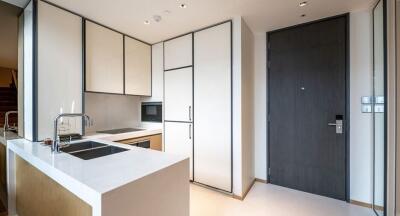 Modern kitchen with white cabinets and a black door