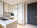 Modern kitchen with white cabinets and a black door