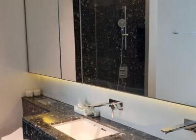 Modern bathroom with marble countertop and large mirror