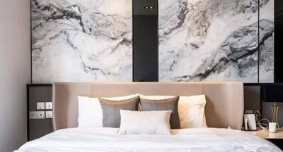 Modern bedroom with a large bed and marble accent wall