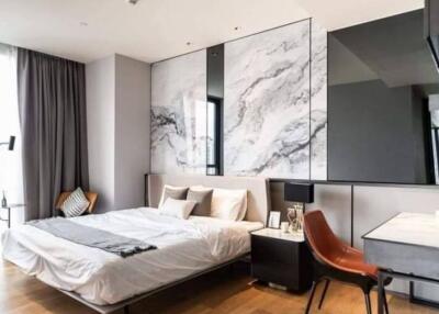 Modern bedroom with large window, marble feature wall, and work desk
