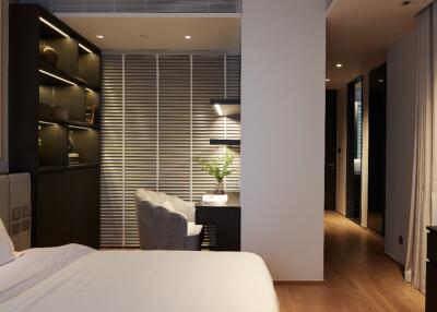 Modern bedroom with desk, shelves, and ample lighting.