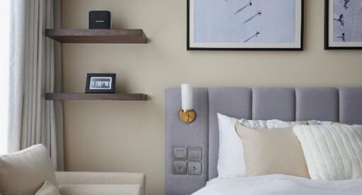 Modern bedroom with wall-mounted shelves and framed art