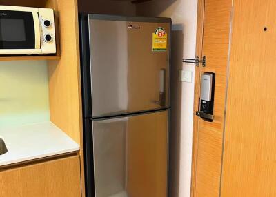 Modern kitchen with fridge, microwave, and electronic door lock