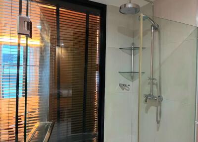 Modern bathroom with glass shower and vertical blinds