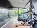 Modern gym with exercise equipment and large windows