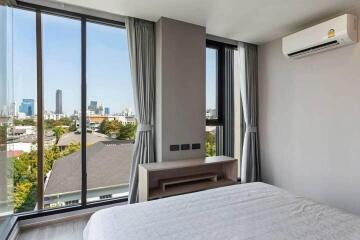 Bedroom with large windows and city view