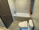 Modern bathroom with bathtub, toilet, and wooden blinds on window