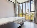 Modern bedroom with large windows and city view