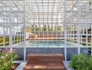 Modern outdoor pool area with geometric white structure and lush greenery