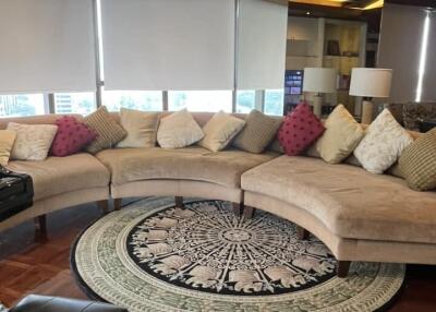 Spacious living room with curved sofa and large rug