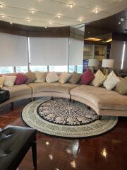 Spacious living room with curved sofa and large rug