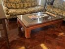 Living room with patterned couches and a glass-top coffee table