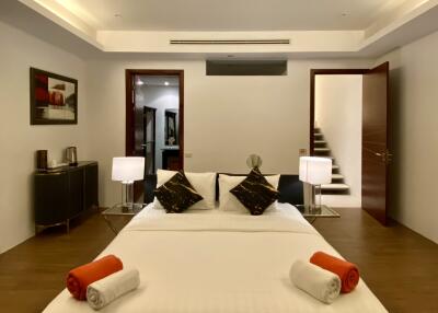 Modern bedroom with a double bed, nightstands, and wall artwork