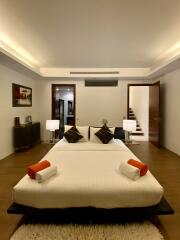 Modern bedroom with a double bed, nightstands, and wall artwork