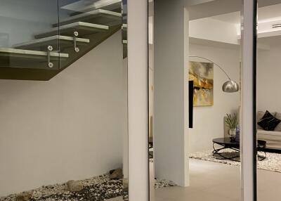 Modern living area with glass staircase and elegant decor