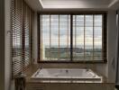 luxurious bathroom with jacuzzi and large windows with scenic view