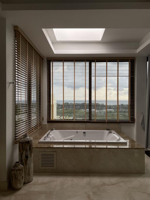 luxurious bathroom with jacuzzi and large windows with scenic view