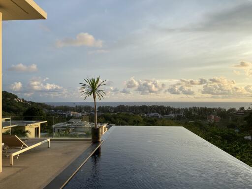 Infinity pool with ocean view and lush greenery