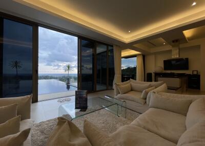 Modern living room with large glass doors, ocean view, and comfortable seating