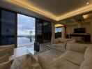 Modern living room with large glass doors, ocean view, and comfortable seating