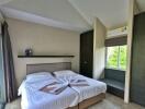 Well-lit modern bedroom with double bed and a large window