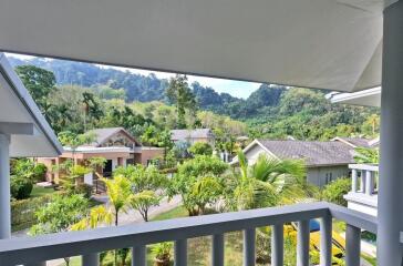 Balcony with view of a lush green landscape and surrounding buildings