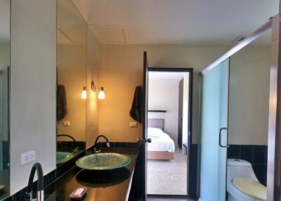 Modern bathroom with a vessel sink and a view into a bedroom