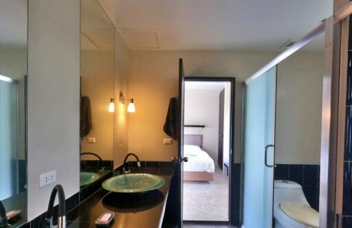 Modern bathroom with a vessel sink and a view into a bedroom