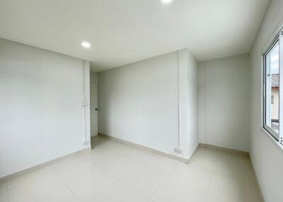 Empty bedroom with white walls and floor tiles