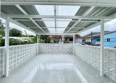 Spacious covered balcony with tiled floor and decorative railing