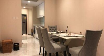 Dining area with table set for four and view into kitchen