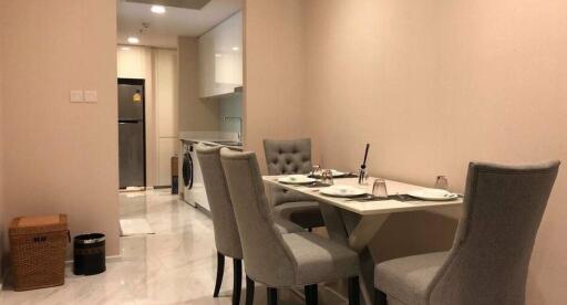 Modern dining area with a table set for four adjacent to the kitchen