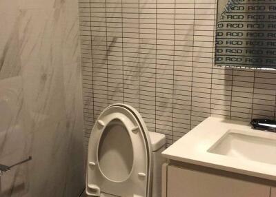 Bathroom with modern design featuring a toilet, sink, and wall mirror