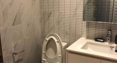 Bathroom with modern design featuring a toilet, sink, and wall mirror