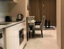 Modern kitchen leading to a dining area with gray chairs