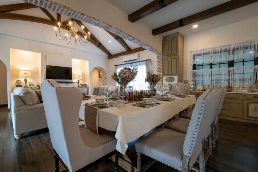 Elegant dining room with table set for dinner and cozy living area