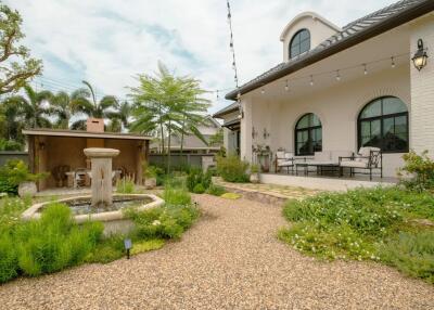 Beautiful garden area with water fountain and house