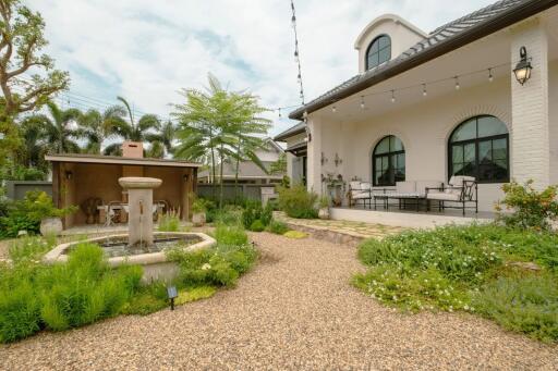 Beautiful garden area with water fountain and house