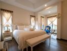 Cozy bedroom with large bed, bench, and natural lighting