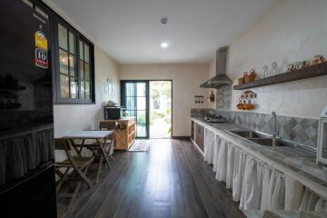 Spacious kitchen with a large window, modern appliances, and a wooden dining area