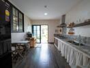 Spacious kitchen with a large window, modern appliances, and a wooden dining area