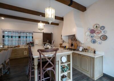Spacious kitchen with a large island, wooden beams, and decorative plates